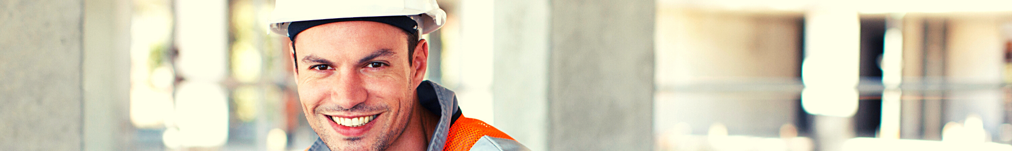 עובד בניין חובש קסדת בטיחות מחייך